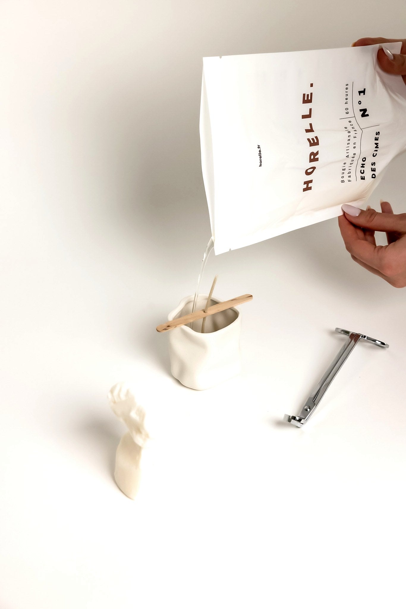 Mains versant la cire a l'atelier Horelle, gestuelle artisanale