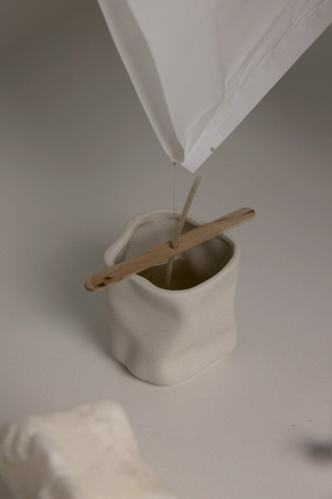 Sachet de cire Horelle versant dans le contenant, angle dynamique