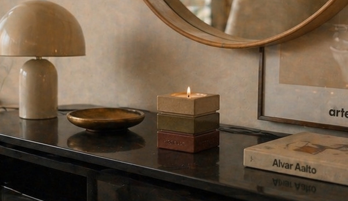 Le contenant signature Horelle sur une console noire, sous une lampe