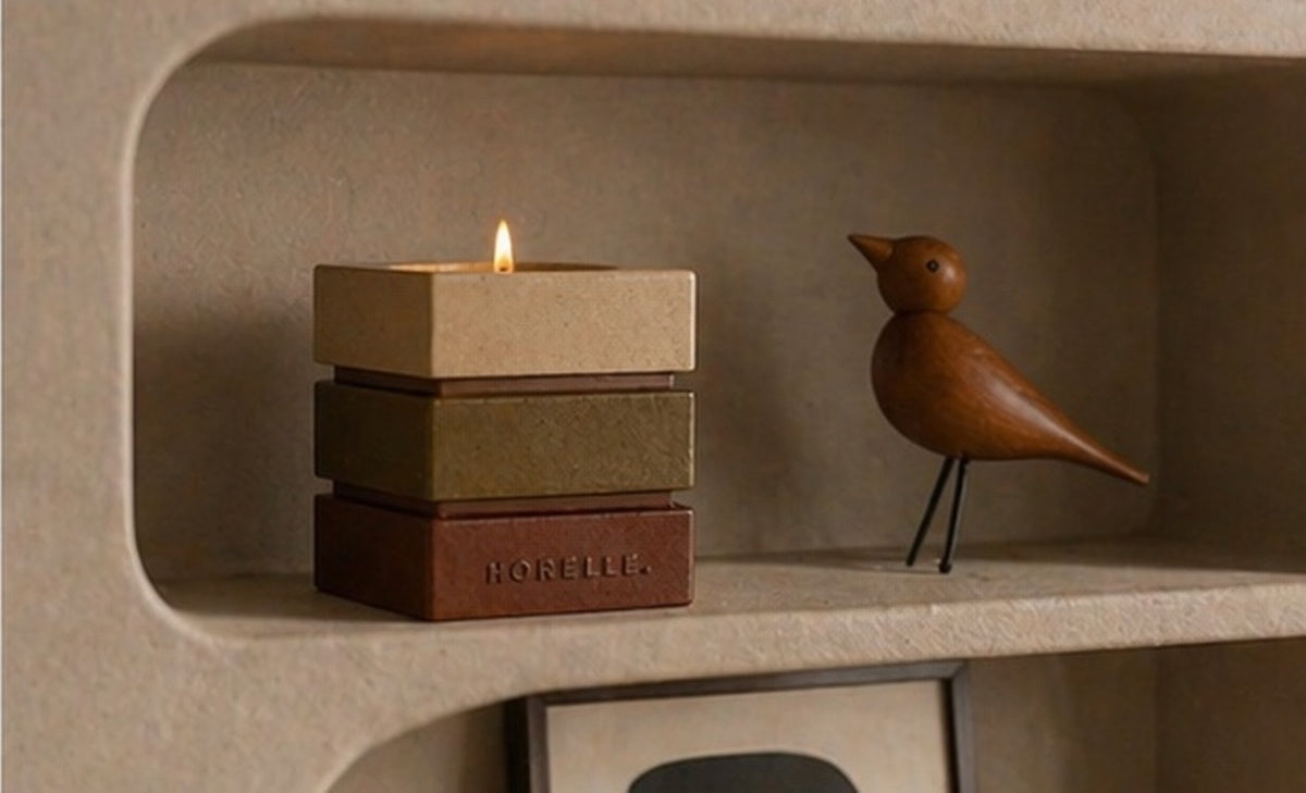 Le contenant signature Horelle dans une niche d'etagere, oiseau en bois